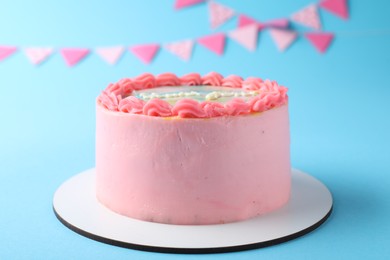 Photo of Cute bento cake with tasty cream on light blue background