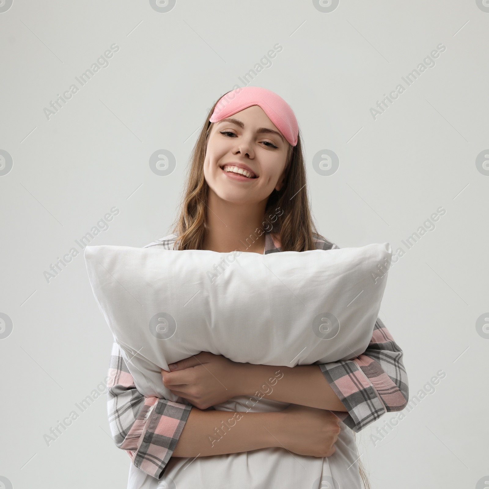 Photo of Beautiful woman with pillow on light grey background. Bedtime