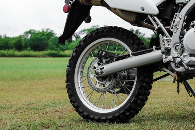 Photo of Cross motorcycle on green grass outdoors, closeup