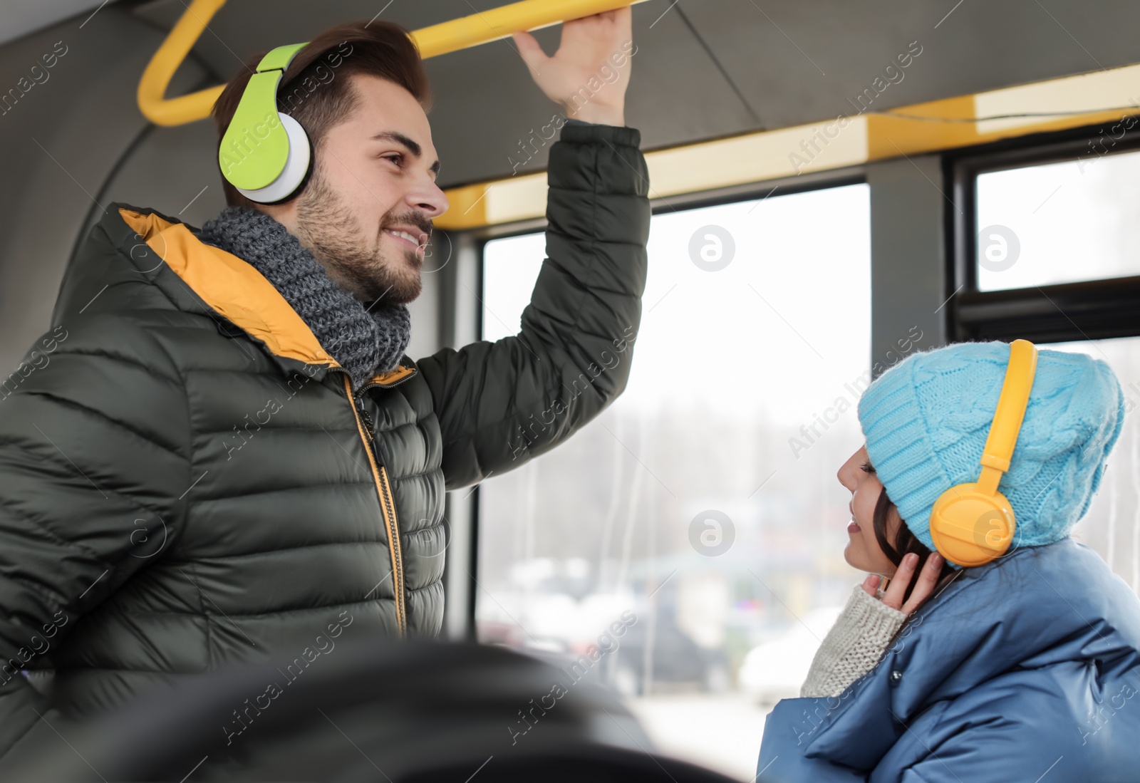 Photo of Young people listening to music with headphones in public transport