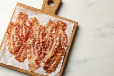 Delicious fried bacon slices on white marble table, top view