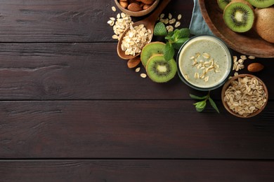 Flat lay composition with tasty kiwi oatmeal smoothie on wooden table. Space for text