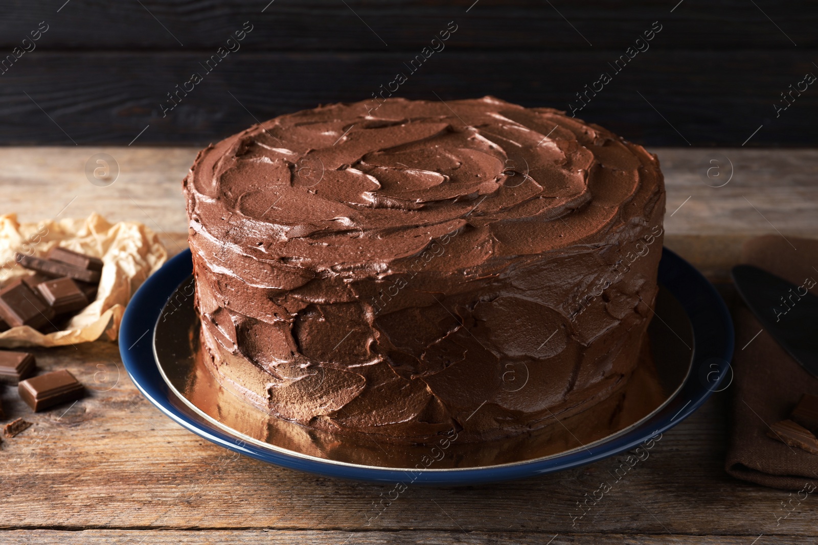 Photo of Plate with tasty homemade chocolate cake on wooden table