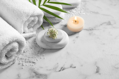 Photo of Beautiful composition with spa stones on white marble table, above view