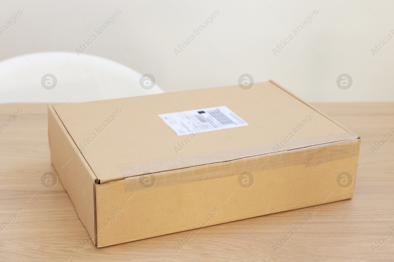 Photo of Cardboard box on wooden table, closeup. Delivery service