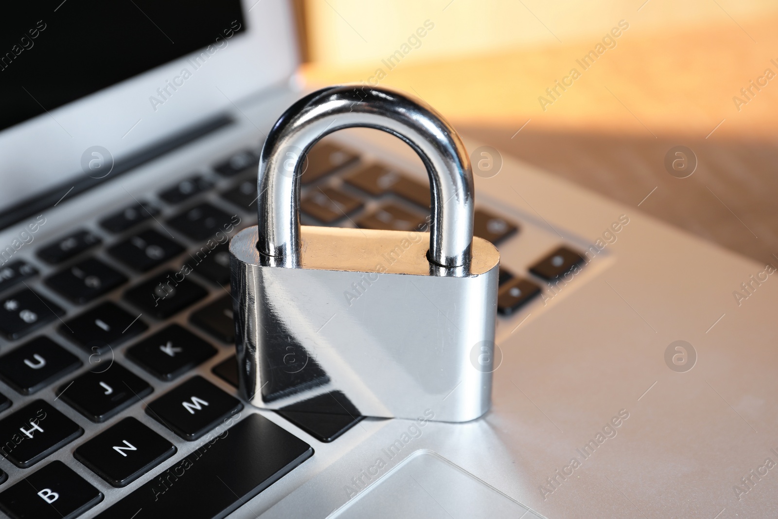 Photo of Cyber security. Laptop with padlock on table, closeup