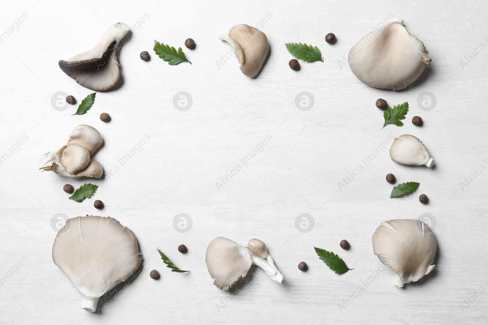 Photo of Frame made of organic oyster mushrooms and leaves on light background, flat lay with space for text