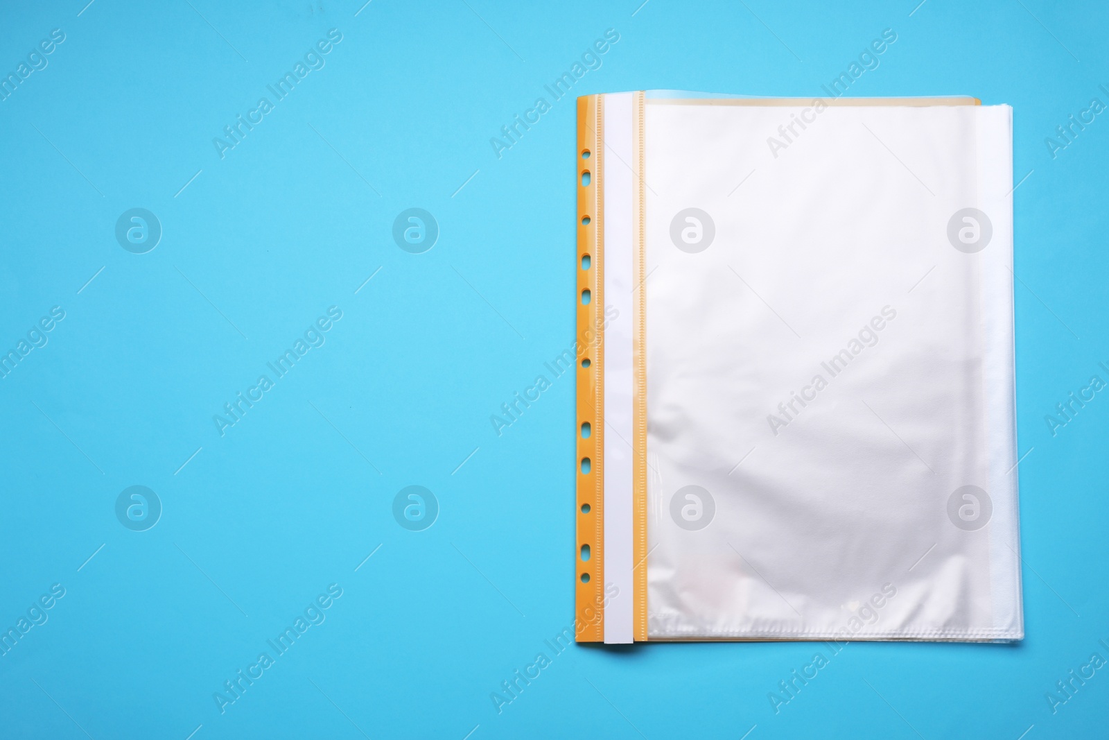 Photo of File folder with punched pockets on light blue background, top view. Space for text