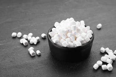 Photo of Bowl with delicious marshmallows on black background