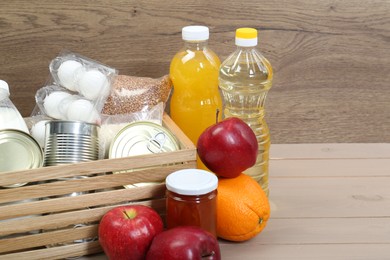 Photo of Different donation food on wooden table, space for text