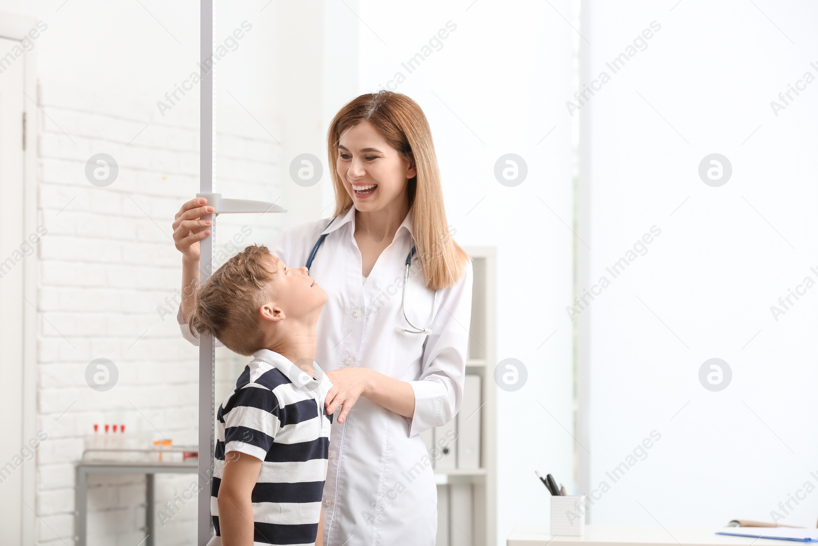 Photo of Doctor measuring little boy's height in hospital