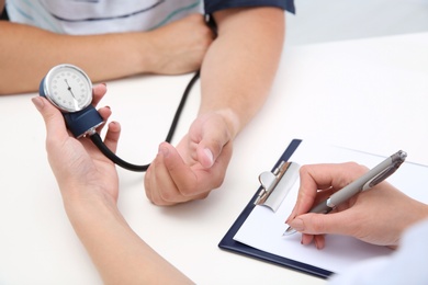 Doctor checking young man's pulse in hospital