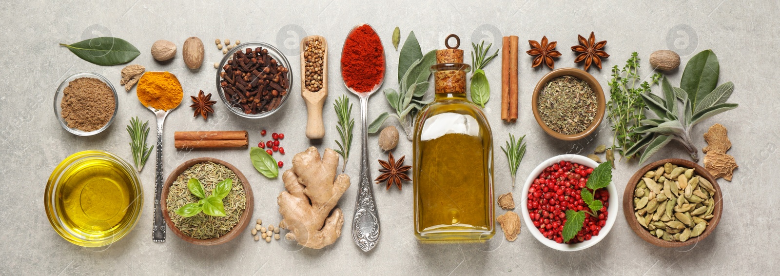 Image of Different herbs and spices on grey table, flat lay. Banner design