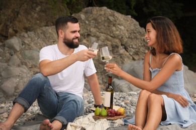 Photo of happy young couple having picnic on beach