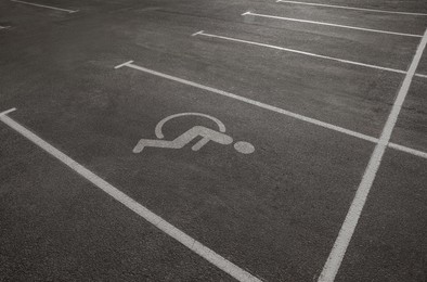 Car parking lot with white marking lines and wheelchair symbol  