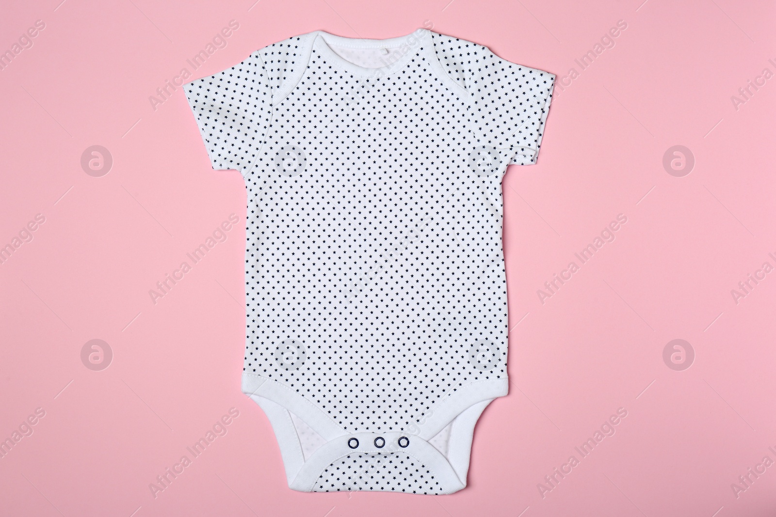 Photo of Cute baby onesie on color background, top view