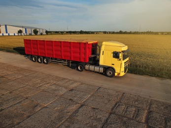 Photo of Modern bright truck on road near wheat field