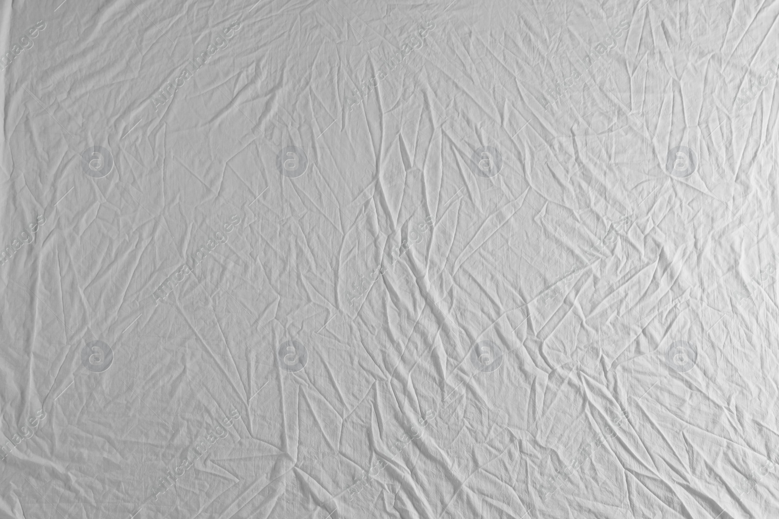 Photo of Crumpled white fabric as background, top view