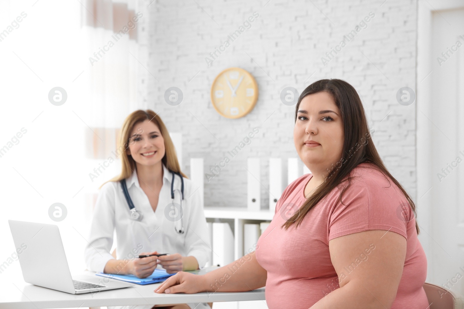 Photo of Female doctor and overweight woman in clinic