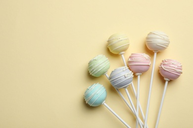 Sweet cake pops on yellow background, flat lay. Space for text