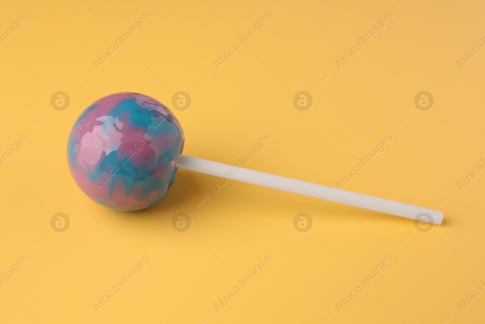 Photo of One tasty lollipop on orange background, closeup