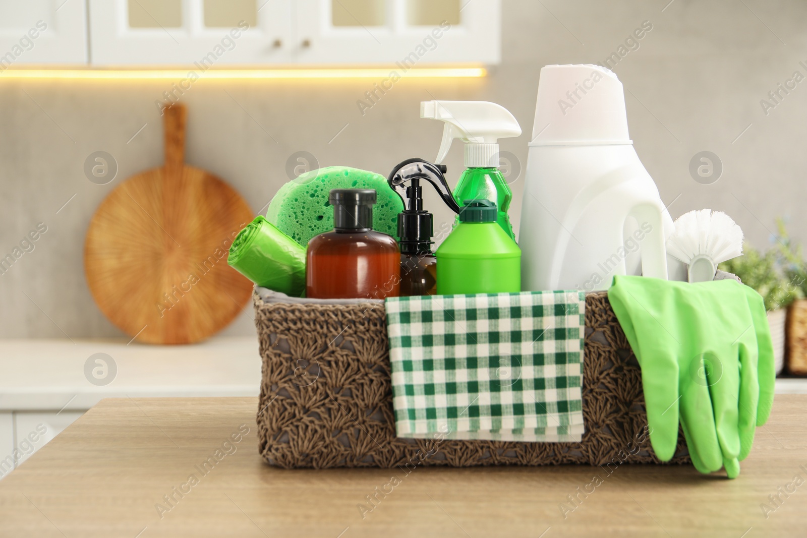 Photo of Different cleaning supplies in basket on table