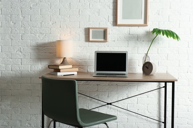 Photo of Stylish workplace with laptop on table in home office. Space for design