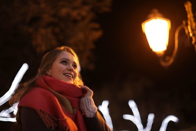 Beautiful young woman spending time in city at night