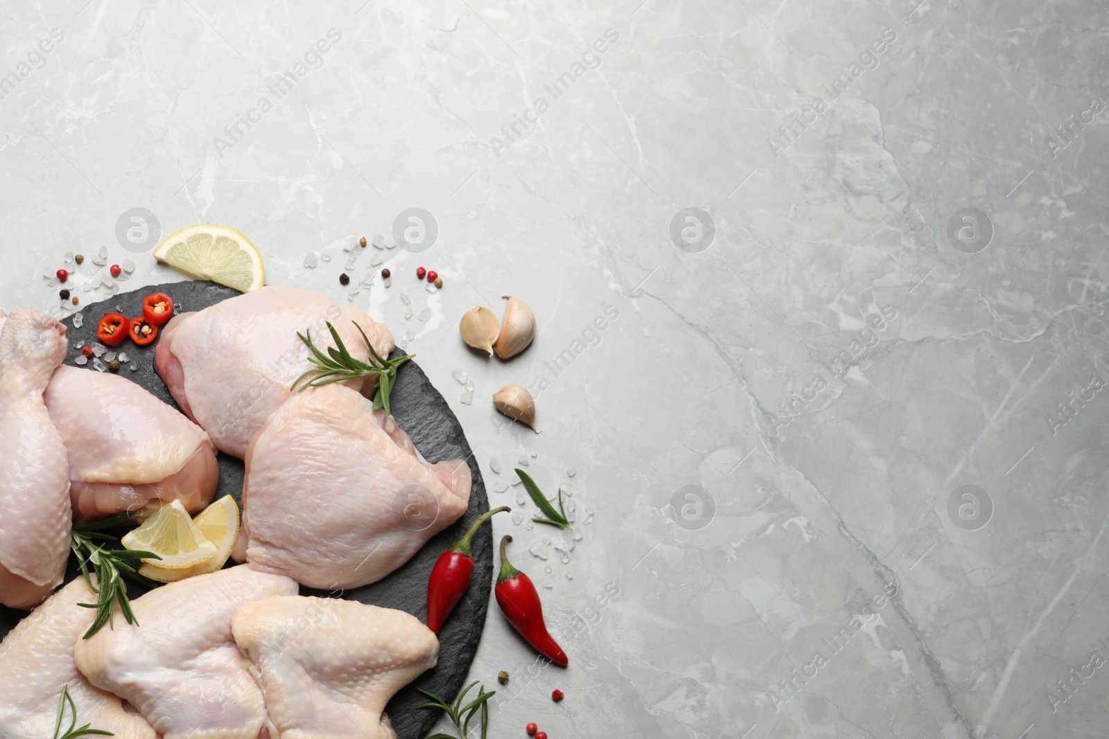 Photo of Flat lay composition with fresh raw chicken meat on light grey table. Space for text