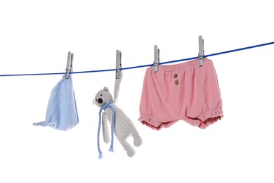 Photo of Baby clothes and toy bear drying on laundry line against white background