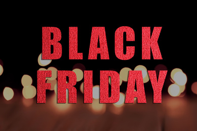Phrase Black Friday and blurred view of beautiful lights on background 