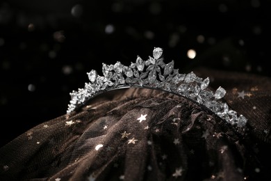 Photo of Beautiful silver tiara with diamonds on dark cloth