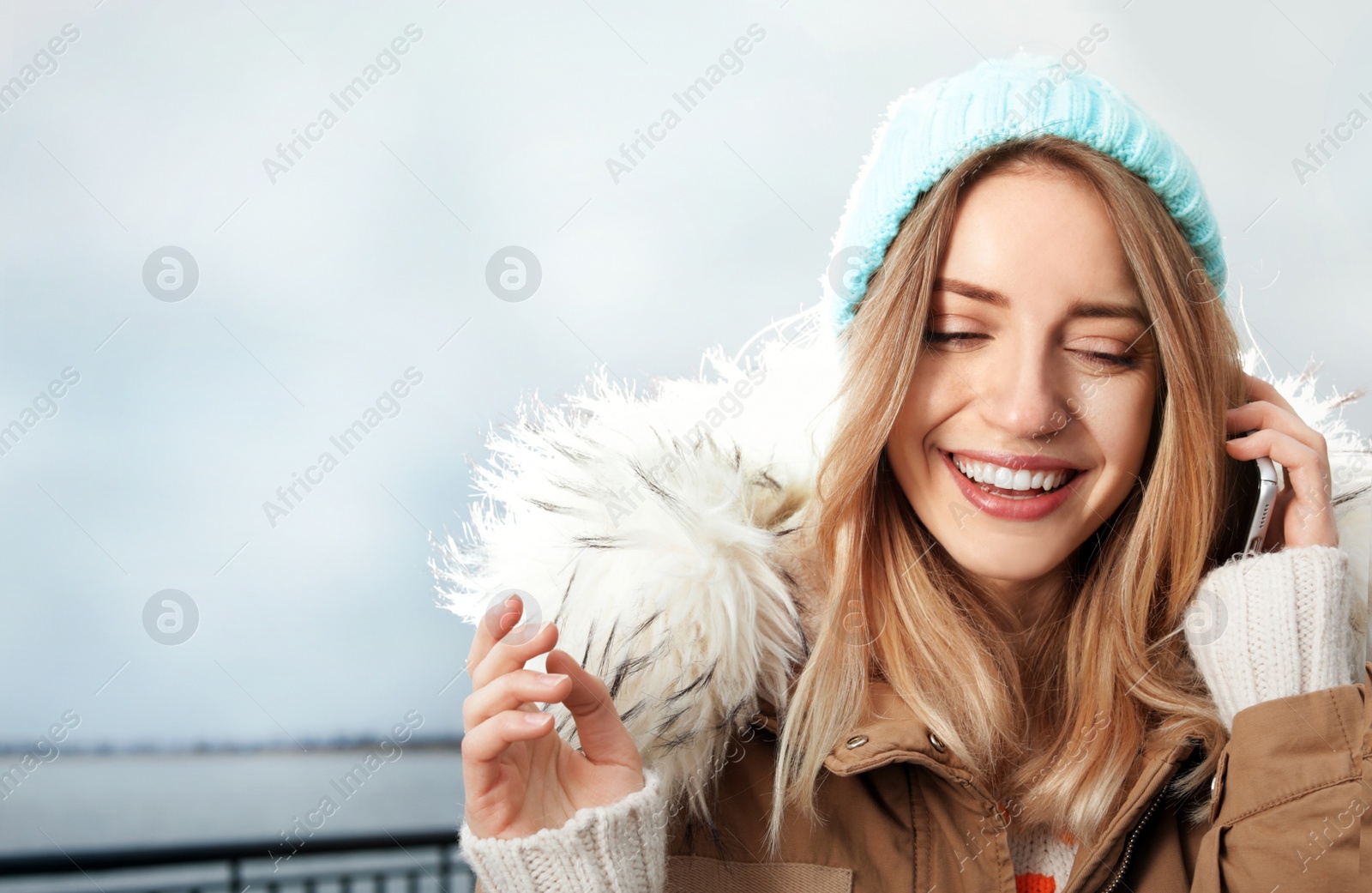 Photo of Young woman talking on mobile phone outdoors. Space for text