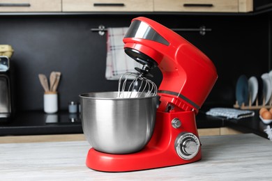 Photo of Modern stand mixer on wooden table in kitchen. Home appliance