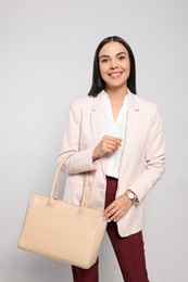 Photo of Young woman with stylish bag on white background