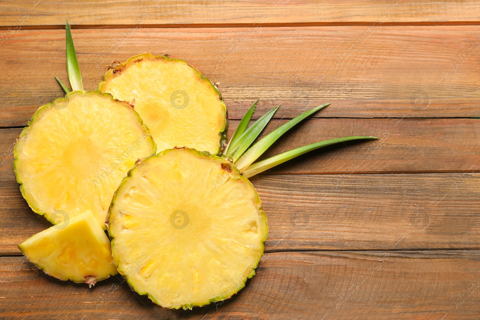 Photo of Flat lay composition with fresh sliced pineapple on wooden background