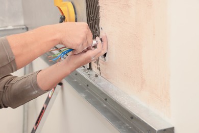 Photo of Worker installing socket in tile indoors, closeup