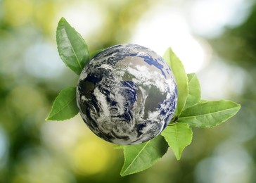Image of Recycling concept. Earth planet with green leaves on blurred background