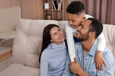 Photo of Happy international family on sofa at home