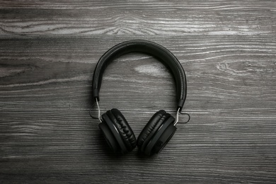 Photo of Stylish headphones on wooden background, top view