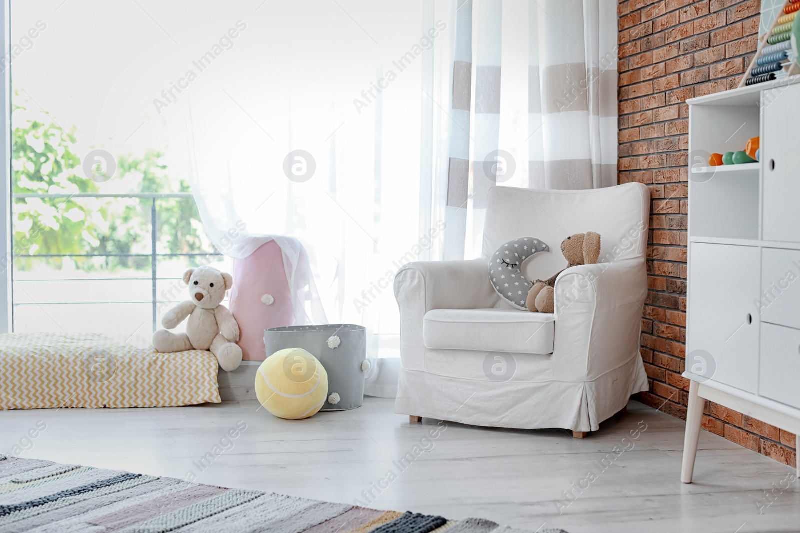 Photo of Stylish child room interior with comfortable armchair