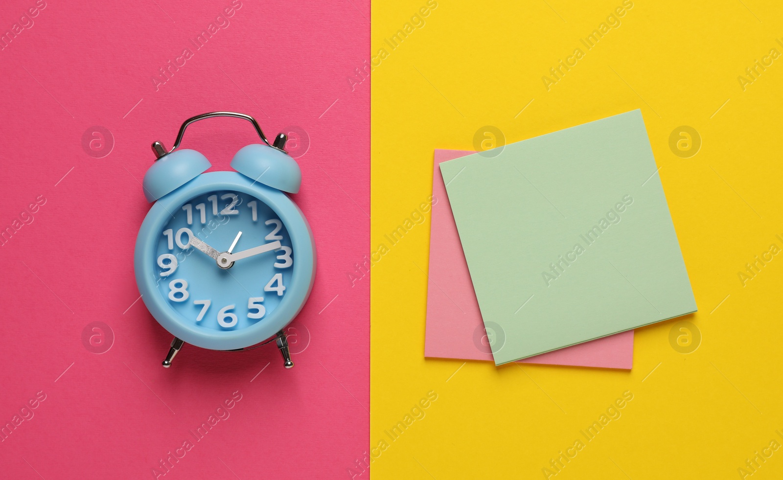 Photo of Alarm clock and blank reminder notes on color background, flat lay