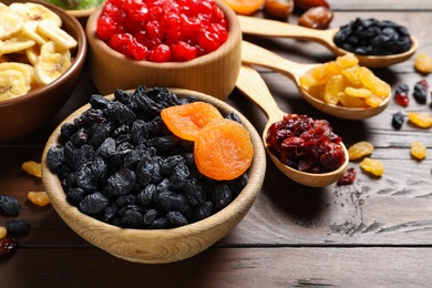 Photo of Composition with different dried fruits on wooden background. Healthy lifestyle