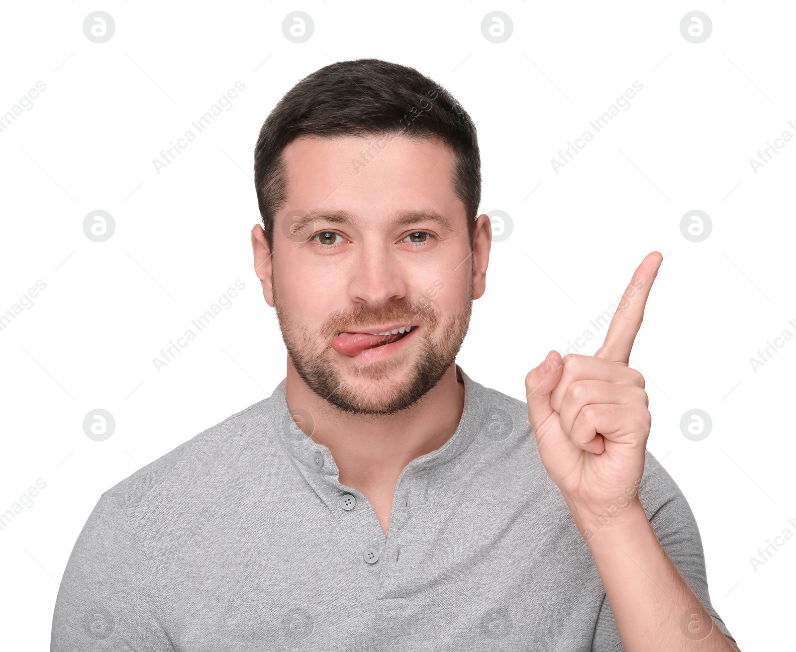 Photo of Happy man showing his tongue and pointing at something on white background