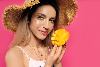 Photo of Young woman with fresh mango on pink background. Exotic fruit