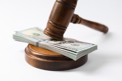 Photo of Law gavel with stack of dollars on white background, closeup