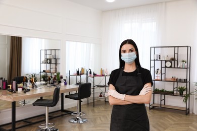 Photo of Professional stylist with protective mask in salon, space for text. Hairdressing services during Coronavirus quarantine