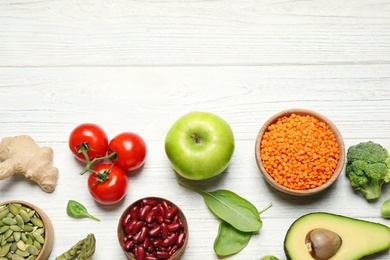 Different vegetables, seeds and fruits on white wooden table, flat lay with space for text. Healthy diet