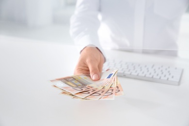 Teller with money at cash department window, closeup