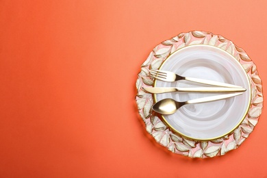 Photo of Elegant table setting on orange background, flat lay. Space for text